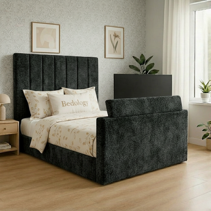 Gray upholstered bed with green bedding in a bedroom setting.